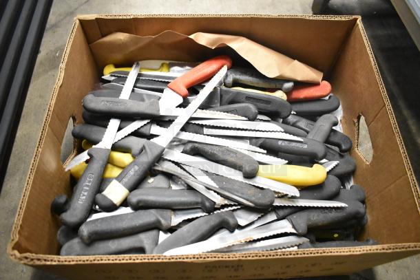 Box of 80 sharpened stainless steel knives, including serrated. Black, yellow, red handles, mixed conditions.
