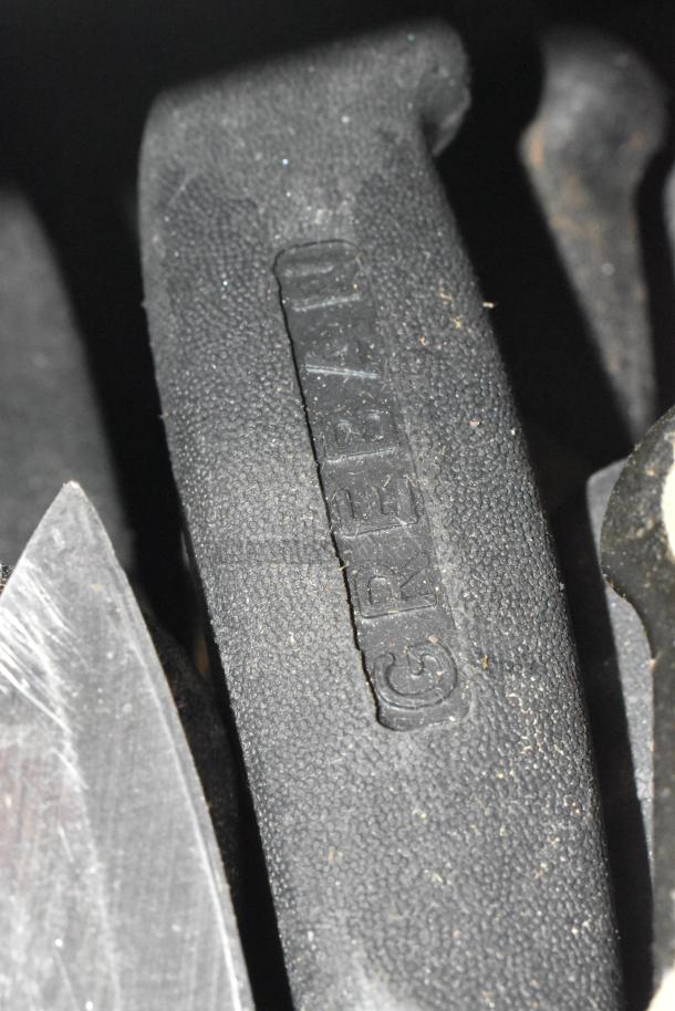 Close-up of a black handle marked "GREEN" on a sharpened stainless steel knife, from a batch of 100 including chef knife.