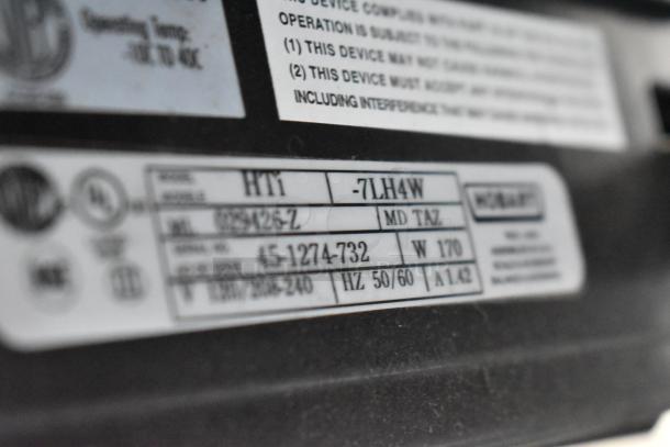 2023 Hobart HTi-7LH4W scale label showing model, serial number, voltage, and manufacturer details.