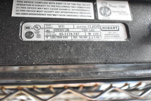 2017 Hobart HTi-7LH26 food portioning scale label showing model details and voltage specifications.
