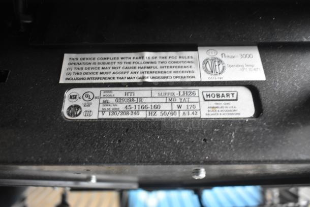 2017 Hobart HTi-7LH26 scale label, shows compliance details, model, serial number, and voltage information.