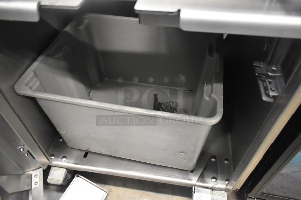 LATE MODEL JBT 2ND-GEN-MFJ-HE Commercial Citrus Juicer with casters. 115 Volts, 1 Phase. Shown with a gray bin.