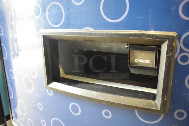 Metal commercial bottled drink vending machine with bill acceptor, 115 volts, 1 phase, blue with circular pattern, change slot visible.