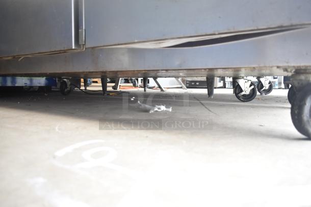 Traulsen G30013 Commercial 3 Door Reach In Cooler, 115V, 1 Phase, visible wheels and base condition in image.