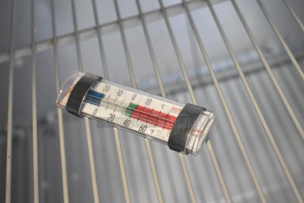 Thermometer inside a Traulsen G30013 Commercial 3 Door Reach In Cooler, displayed on wire shelving.