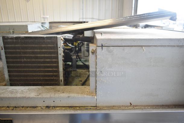 Traulsen G30013 Commercial 3 Door Reach In Cooler, 115 Volts, 1 Phase. Visible wear on exterior surface, industrial setting.