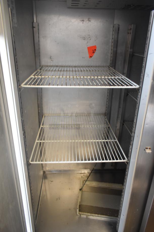 McCall 4-4070 commercial cooler, 3 doors, interior view with steel shelves, visible wear, model label partially shown, 115V, 1 phase.
