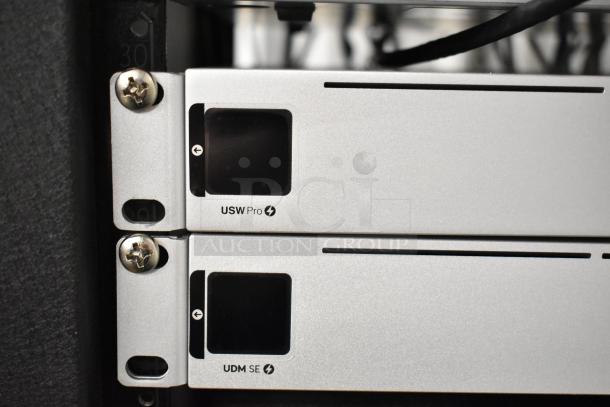 AV Cabinet with USW Pro and UDM SE Rack Units, shown in a metal frame with visible mounting screws.