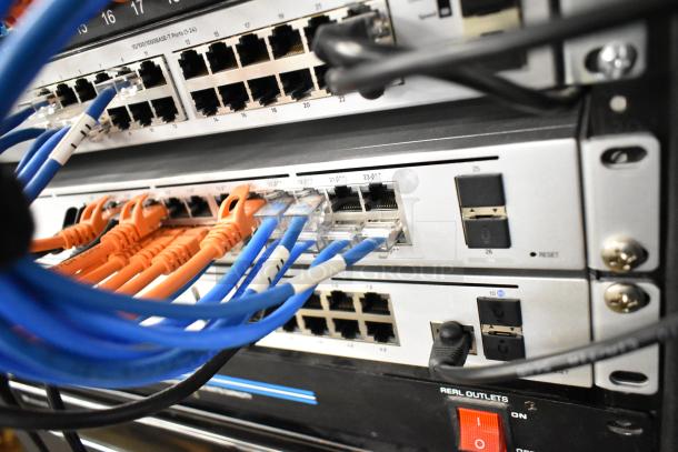 AV cabinet featuring network and power equipment, orange and blue cables connected, visible power switch, in good condition.