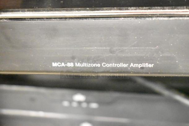 Russound MCA-88 Multizone Controller Amplifier close-up, showing model marking. Black finish, part of AV collection.