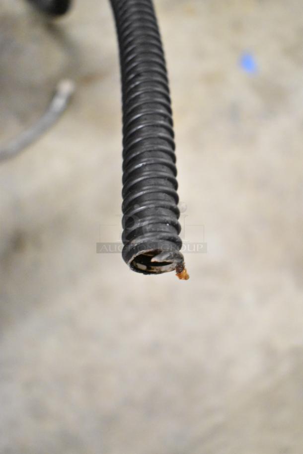 Close-up of a damaged black hose end, part of the Torrie MTE225XC70 espresso machine.