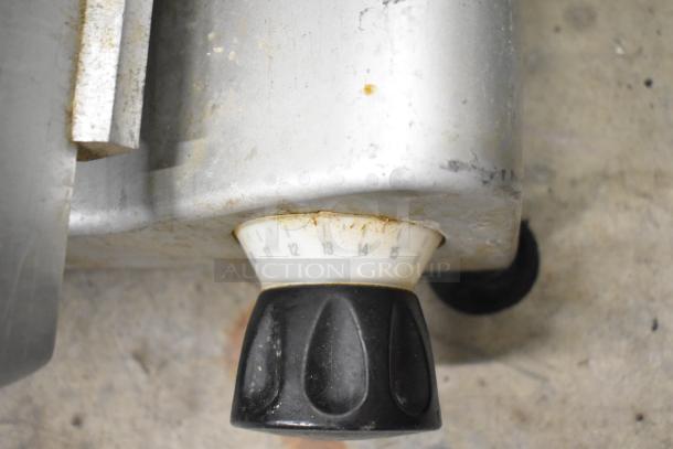 Avantco 177SL312 meat slicer control knob showing 1-15 dial settings, indicating adjustable slice thickness. Some wear visible.