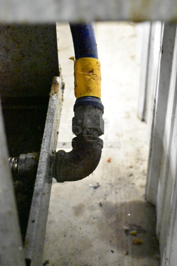alt text: "Natural gas connection for Pitco Frialator 40D deep fat fryer, showing gas hose and fittings."