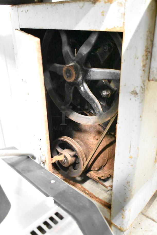 Hobart commercial floor-style meat saw, showing internal wheel mechanism. Visible rust, indicating used condition.