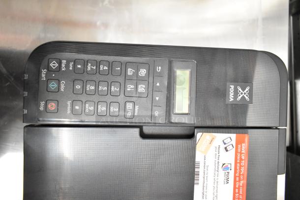 Canon K10546 multifunction printer, black, keypad and small display visible. Features PIXMA branding and promotional sticker.