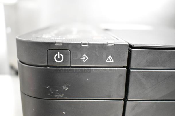 Canon K10546 Multifunction Printer in black. Features icons for power, paper feed, and alert. Slight surface wear visible.