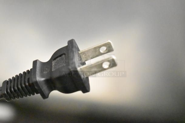 Close-up of Canon K10546 printer plug, showcasing prongs and black housing. Essential component for functionality.