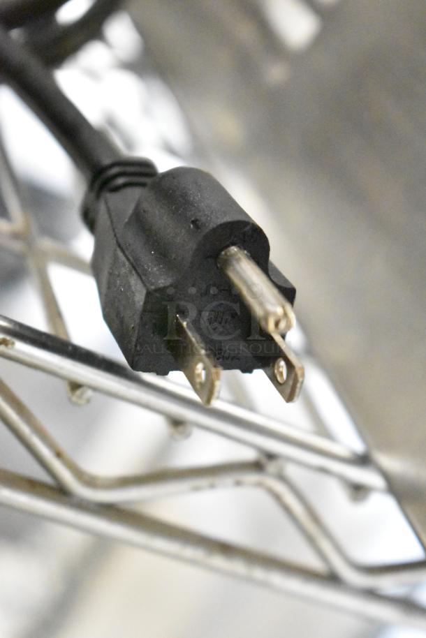 2025 Adcraft FW-1200W Food Warmer plug. Black, three-prong plug on a metal rack. 120 Volts, 1 Phase.