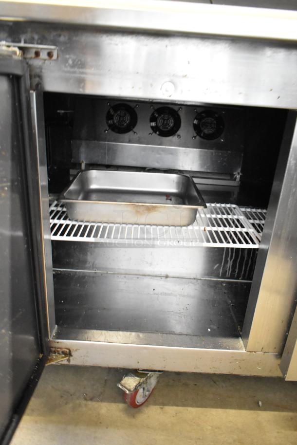 2022 Cooltech CTR-72BMB sandwich salad prep table with open lower compartment, visible casters, and metal tray inside.