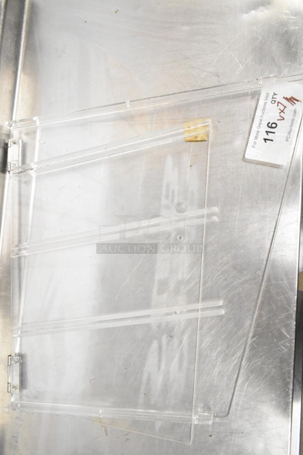 Clear acrylic poly pieces and trays in good condition on metal surface; auction label "116 QTY x7" visible.