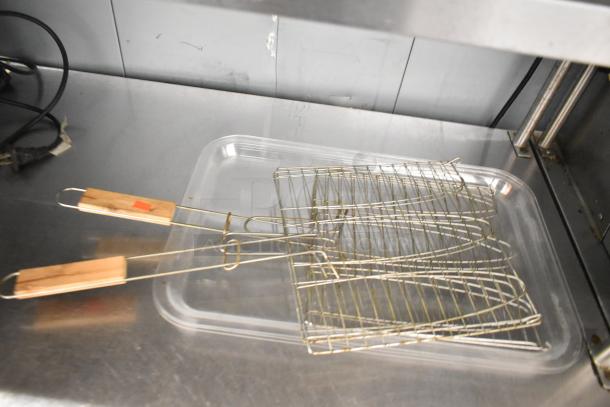 7 various items including metal grilling racks with wooden handles and clear poly trays, in good condition.