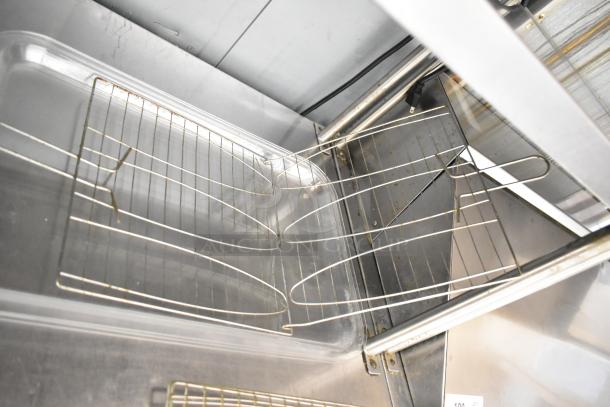 7 various poly trays with metal racks, lightly used, in a metallic industrial setting, auction includes seven items total.