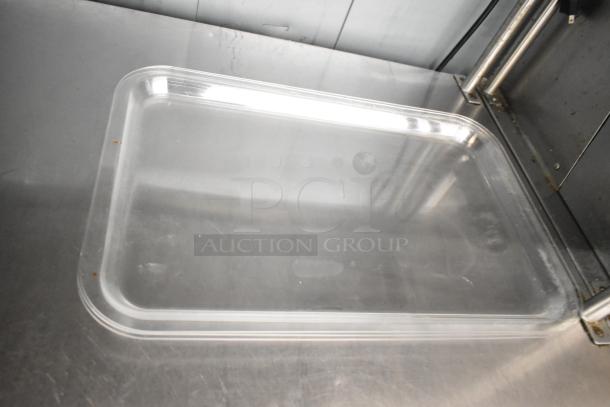 Clear poly tray, rectangular shape, used condition, on metal surface. Part of a lot of 7 miscellaneous items.