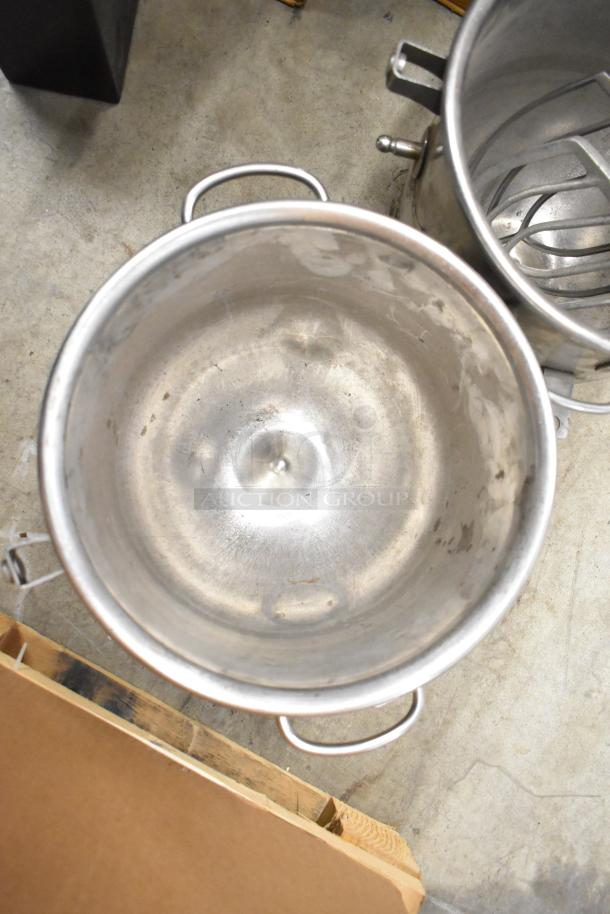 Alt text: Stainless steel mixing bowls and paddle attachments for Hobart mixer. Visible wear, suitable for heavy-duty use.