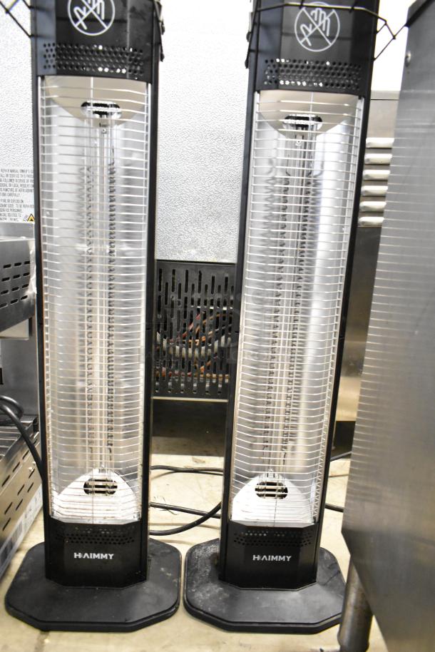 Two Haimmy UEH520 infrared electric heaters, black, vertical design, 120 volts, 1 phase, in clean condition.