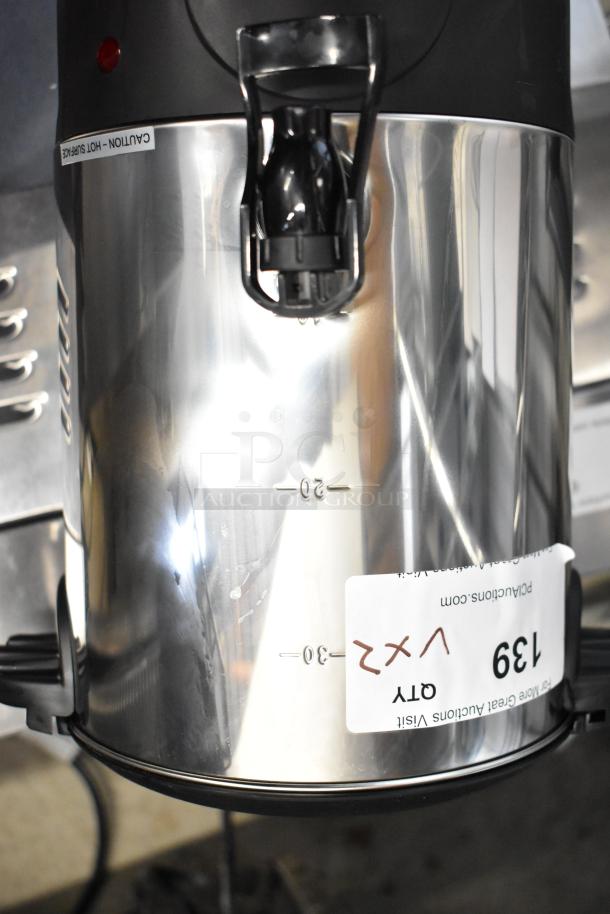 Stainless steel Galaxy 30 Cup coffee urn, brand new, with visible measurement markings and "Caution Hot Surface" label.