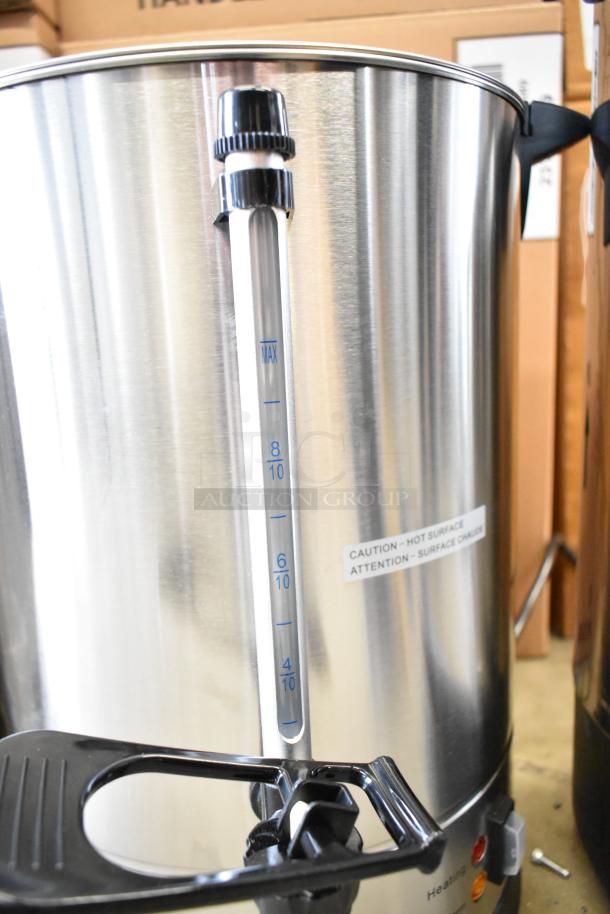 Stainless steel coffee urn with gauge and caution label, part of a lot including Avantco WB29L water boiler. New, scratch-and-dent.