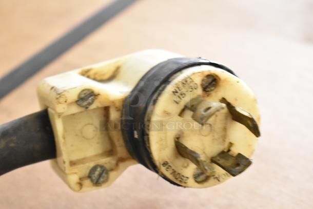 Close-up of a worn plug from a Taylor 8757-33 ice cream machine, showing NEMA L15-30 marking for 208-230V, 3-phase.