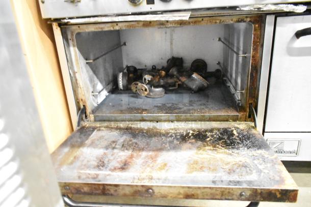 Southbend commercial gas 10-burner range with 2 ovens, over shelf, and backsplash. Visible wear in oven interior.