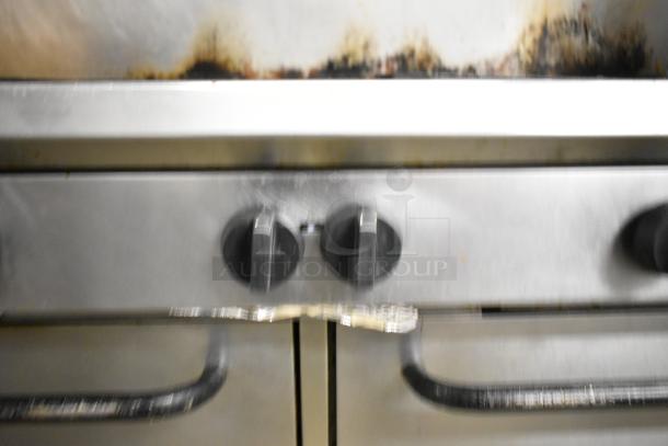 Southbend commercial 10-burner gas range, with 2 ovens, over shelf, backsplash. Stainless steel. Visible wear.