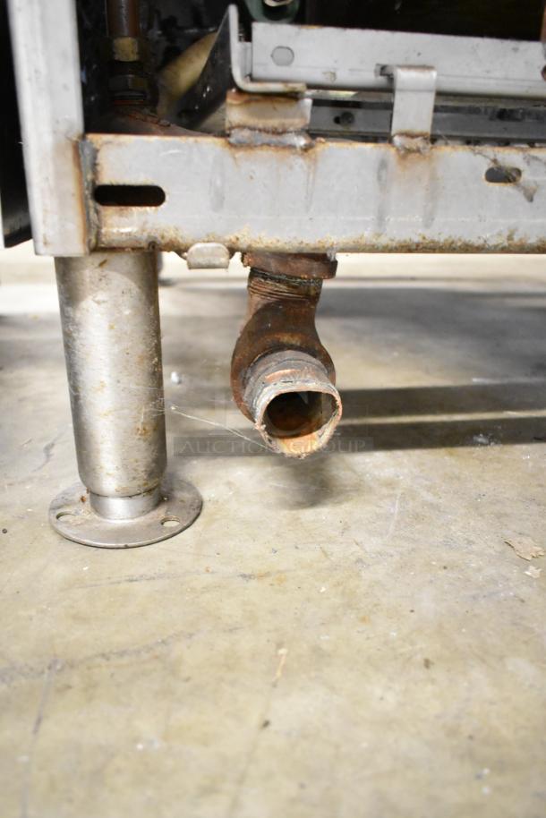 Cleveland Commercial 2 Deck Pressure Steam Cabinet, showing lower piping, in used condition. Rust visible on metal areas.
