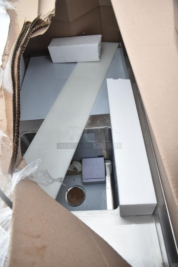 New kitchen unit with minor scratches and dents in original packaging. Includes protective styrofoam and metal components.