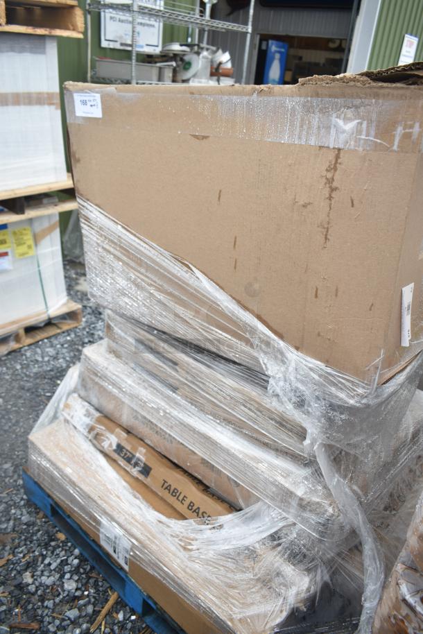 Sealed boxes of 8 new scratch and dent items, including work table and floor mat, on pallet; labeled "Table Base."