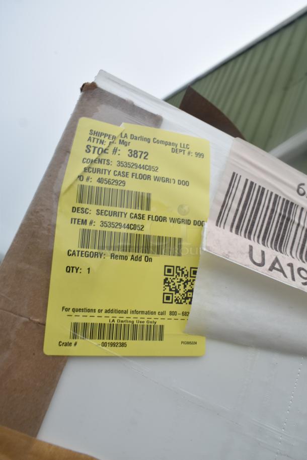 Brand new scratch and dent security case floor with grid, model 35352944C052. Yellow tag shows item and stock details.