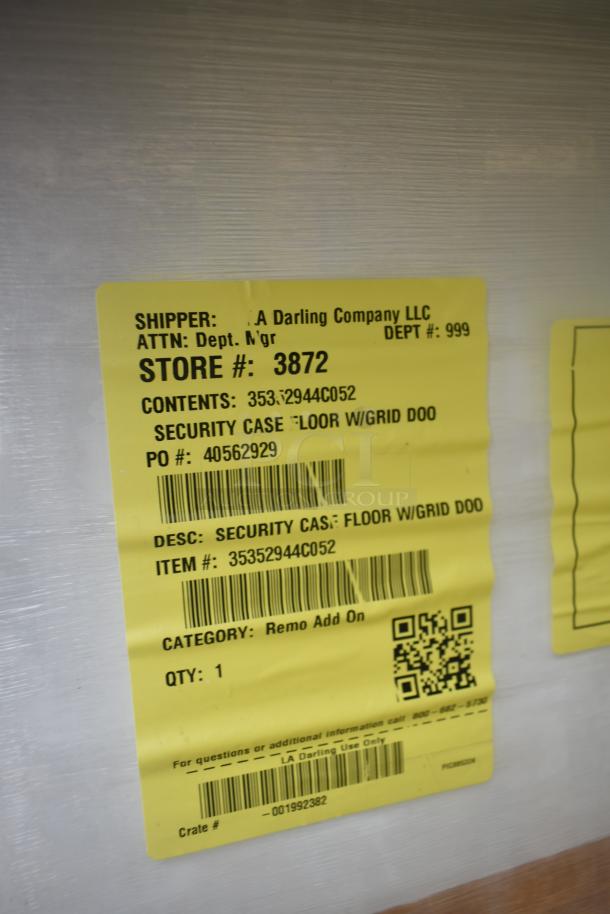 Brand new scratch and dent security case, model 35352944C052, with grid, yellow label detailing item specs and store info.