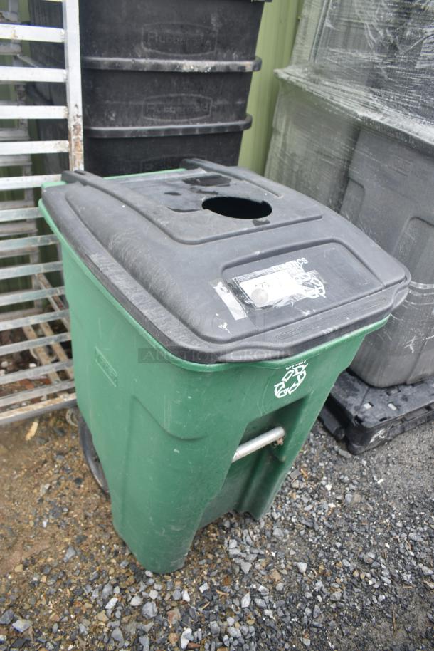 Four trash cans including three black Rubbermaid and one green poly can, slightly weathered.