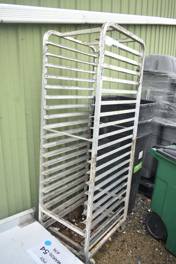 Metal commercial pan transport rack on casters, features multiple shelves. Slight rust visible, suitable for industrial use.