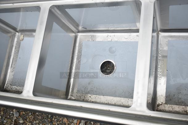 Brand new Regency 600S31818218 stainless steel commercial sink with three compartments and two drainboards, minor scratches.