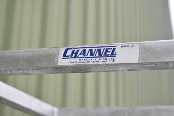 Commercial pan transport rack with casters by Channel Manufacturing, visible label, used condition, durable metal frame.