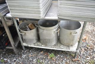 Commercial table with four aluminum stock pots, used condition, two-tier design, metal construction, ideal for kitchen use.