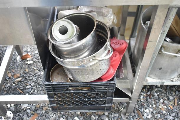 Single bay metal sink with various cooking items including skillets, pots, and red silicone molds, in used condition.