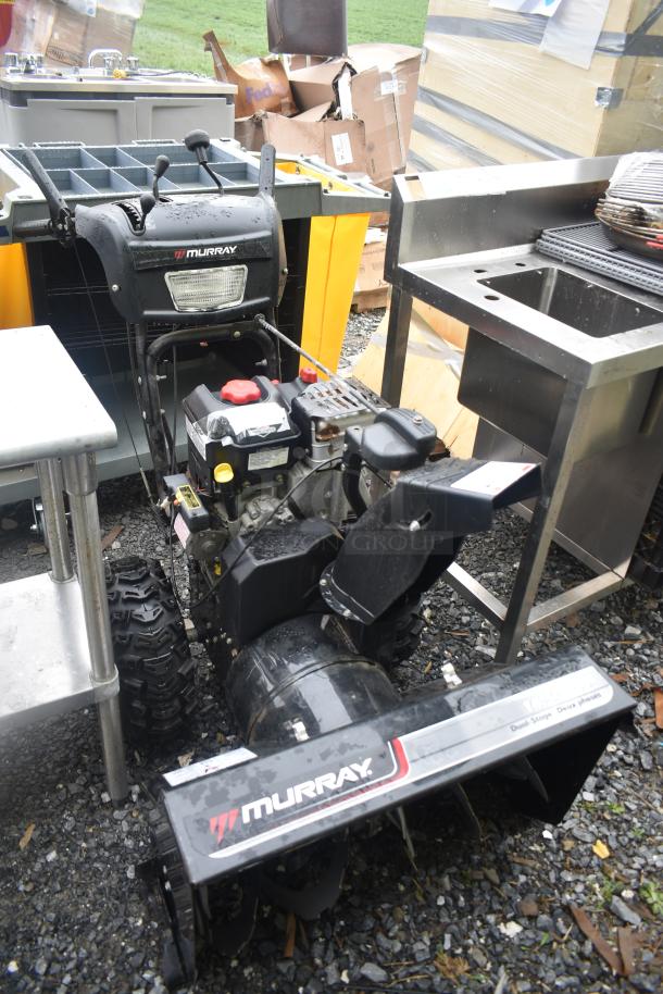 Briggs & Stratton Murray 1695720 Snow Thrower in used condition, visible branding, with sturdy tires and control levers.