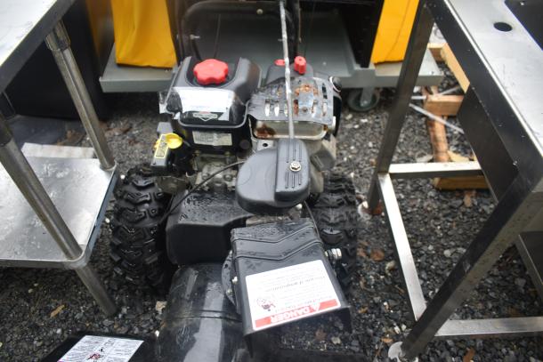 Briggs & Stratton Murray 1695720 snow thrower with visible controls and tires. Slight rust on exhaust cover.