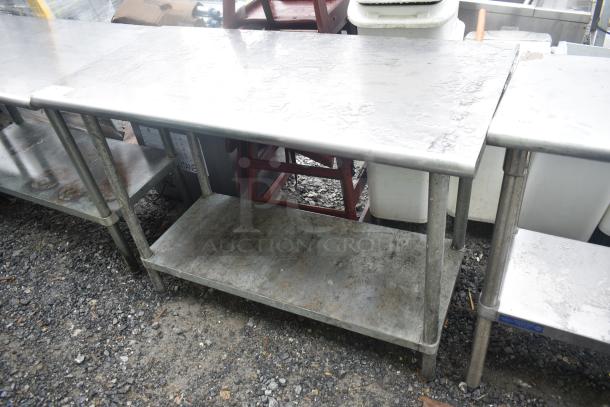 Commercial metal table with under shelf, showing signs of wear and rust. Ideal for kitchen or industrial use.