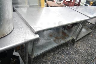 Commercial stainless steel table with under shelf, used condition, surface rust visible, sturdy construction. Ideal for kitchens.