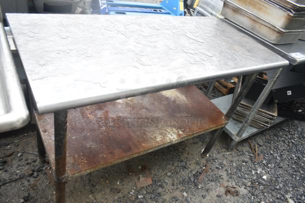 Commercial table with under shelf, metal top, visible rust on the lower shelf, in used condition.